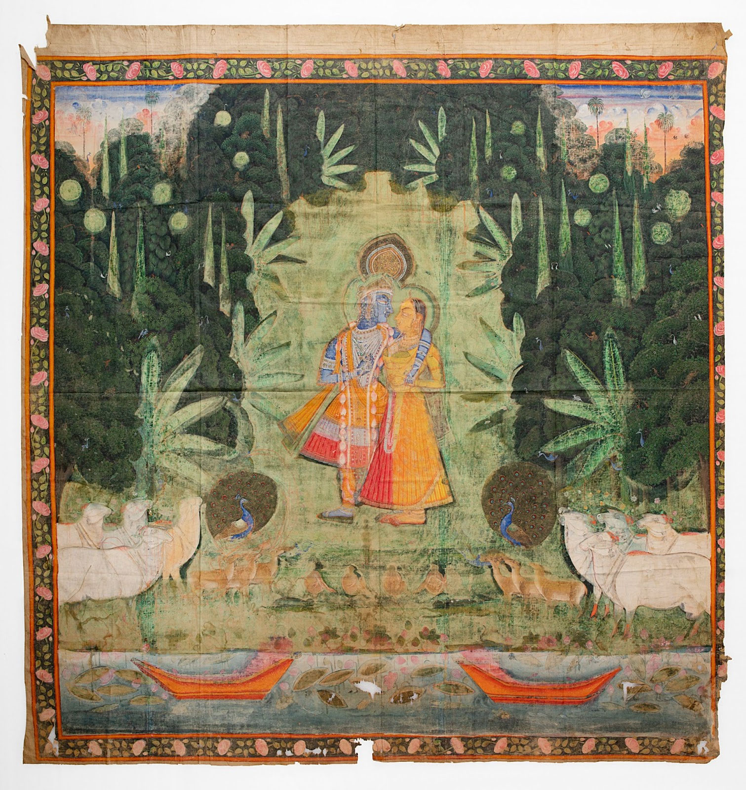 A painting on cloth of the hindu God, Krishna, embracing his partner, Radha, in the forest surrounded by animals and trees.