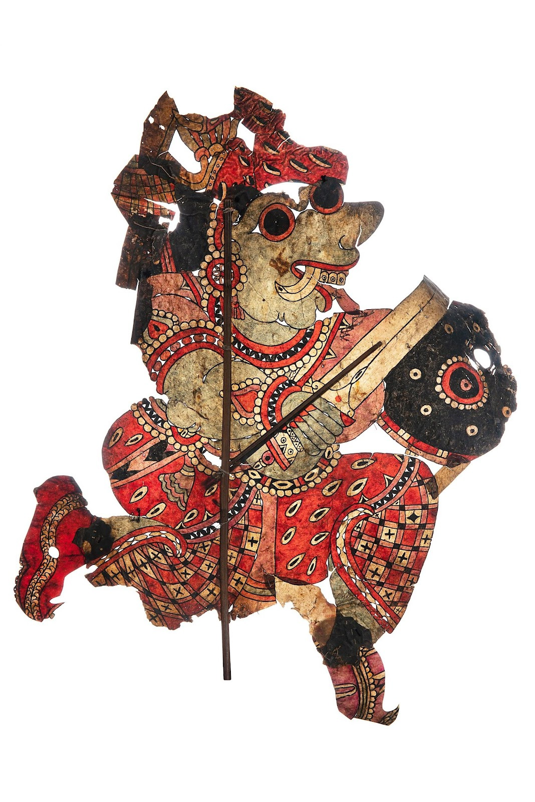 She is created in profile and holds a sword and a shield in her hands. She seems ready to battle. Her expression is fierce with bulging eyes and tongue hanging out.