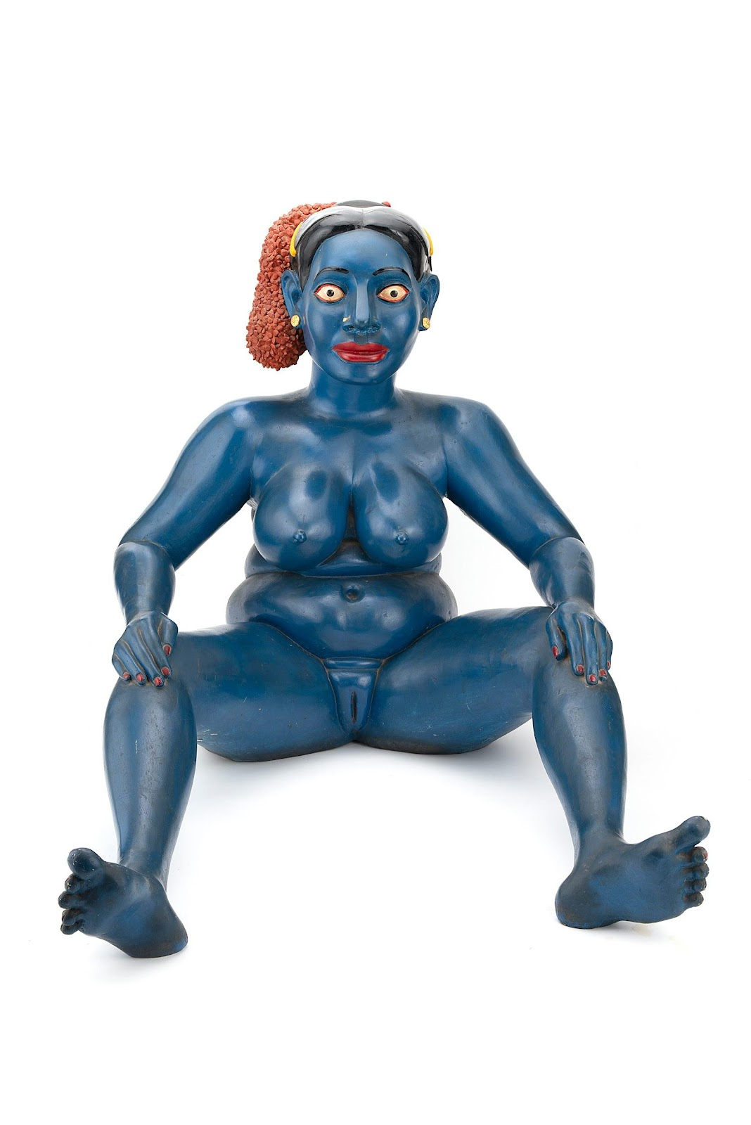 This is a sculpture of a blue-skinned, nude woman with wide eyes and a rounded body.